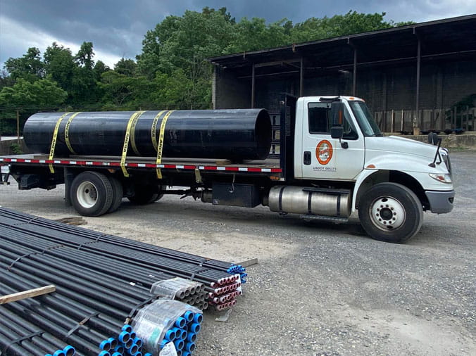 Hajoca Roanoke delivery truck loaded with large pipe